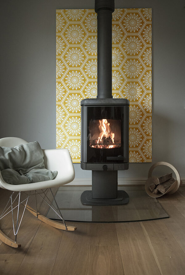 Fire in living room stove with patterned tiles behind